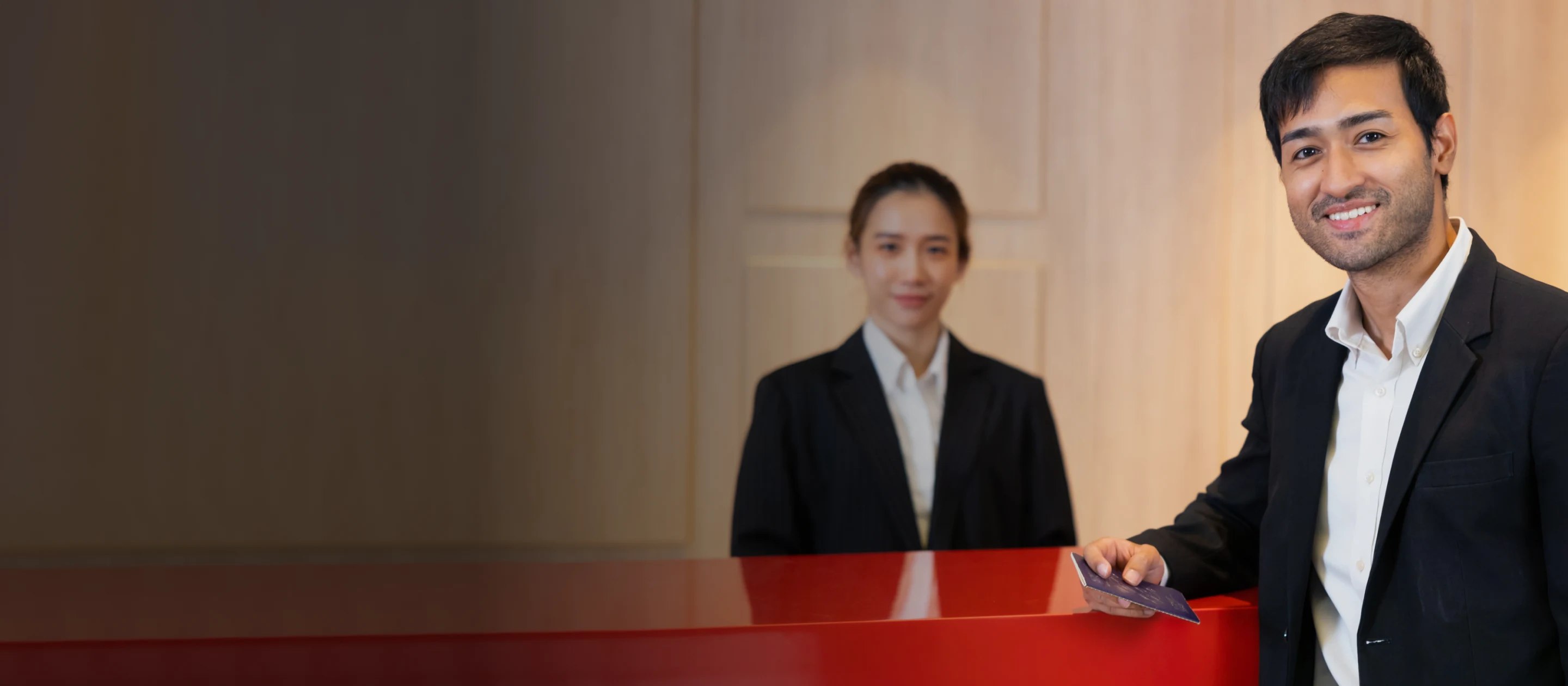 Hotel team welcoming a guest at the front desk